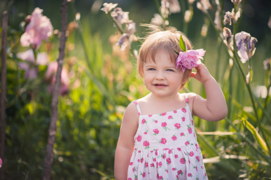 Rustic girl names: little girl with flower behind ear in garden